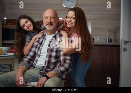 Famille heureuse de trois posant pour la caméra dans la cuisine Banque D'Images