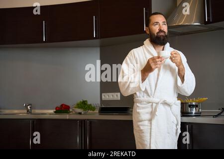 Homme dans un peignoir apprécie le café du matin Banque D'Images