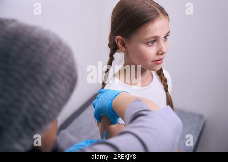 L'enfant dans la salle d'injection reçoit une injection dans le bras Banque D'Images