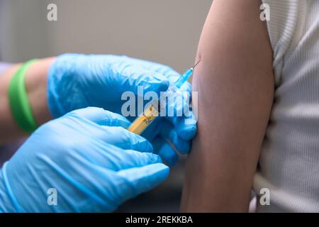 Le patient dans la salle d'injection reçoit l'inoculation prophylactique dans le bras Banque D'Images