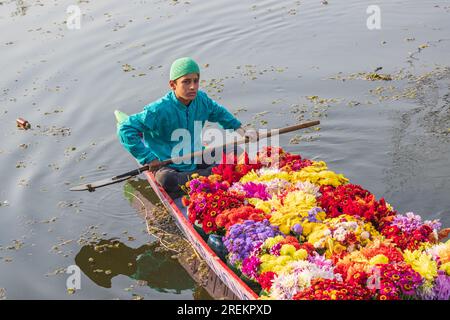 Rainawari, Srinagar, Jammu-et-Cachemire, Inde. 25 octobre 2022. Garçon livrant des fleurs au marché dans un bateau shikara traditionnel au lac Dal. Banque D'Images