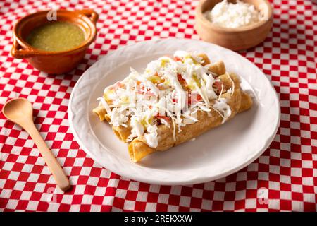 Tacos Dorados. Le plat mexicain également connu sous le nom de Flatas, se compose d'une tortilla de maïs roulé avec un peu de garniture, communément poulet ou boeuf ou option végétarienne Banque D'Images