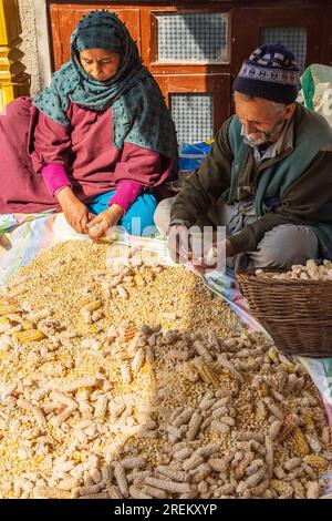 Berna Bugh, Kangan, Jammu-et-Cachemire, Inde. 27 octobre 2022. Homme et femme épluchant le maïs séché de l'épi dans un village du Jammu-et-Cachemire. Banque D'Images