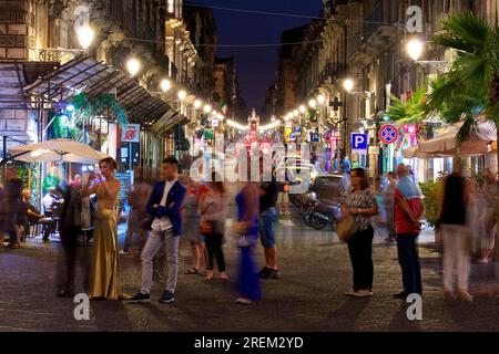 Groupe de personnes, flou, longue exposition, rue commerçante, lanternes, Photo de nuit, vieille ville baroque, Catane, côte est, Sicile, Italie Banque D'Images