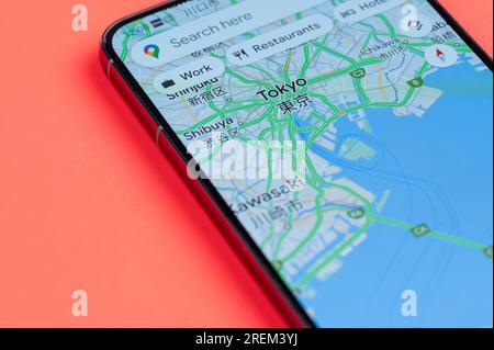 New York, États-Unis - 21 juillet 2023 : distribution du trafic automobile Tokyo dans google maps sur écran smartphone vue rapprochée avec fond rouge Banque D'Images