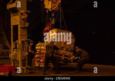 OCÉAN INDIEN (26 juillet 2023) les marins reçoivent des cargaisons dans la baie du hangar à bord des États-Unis Le seul porte-avions déployé à l’avant de la Marine, l’USS Ronald Reagan (CVN 76), lors d’un réapprovisionnement en mer avec le graisseur de réapprovisionnement de la flotte du Military Sealift Command USNS Rappahannock (T-AO 204), dans l’océan Indien, le 26 juillet 2023. Commandant de la Force opérationnelle (CTF) 73, en coordination avec le Military Sealift Command Far East (MSC FE), ravitaille et ravitaille les forces navales déployées, ainsi que les alliés régionaux et les partenaires dans l'Indo-Pacifique. Ronald Reagan, le navire amiral du Carrier Strike Group 5, fournit une force prête au combat Banque D'Images