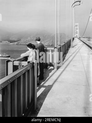 San Francisco, Californie : octobre 1937 les piétons profitent de la vue vers l'ouest depuis la passerelle sur le Golden Gate Bridge récemment ouvert. Banque D'Images