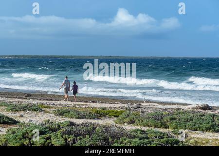 Un couple se promène le long de la plage sur la côte est de Bonaire, pays-Bas des Caraïbes Banque D'Images