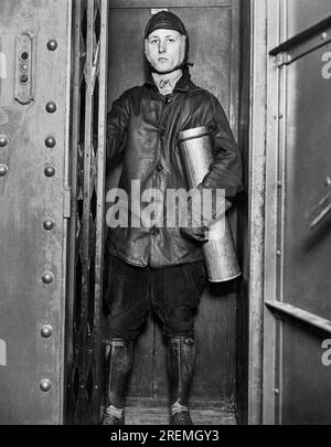 Chicago, Illinois : 28 octobre 1930 le gardien Lindbergh Beacon dans le plus petit ascenseur du monde qu'il prend au sommet du Palmolive Building. La cartouche contient l'alimentation nocturne de charbon pour la balise. Il ajoutera des lunettes d'aviateur et des bottes chaudes à mesure que le temps se refroidit. Banque D'Images