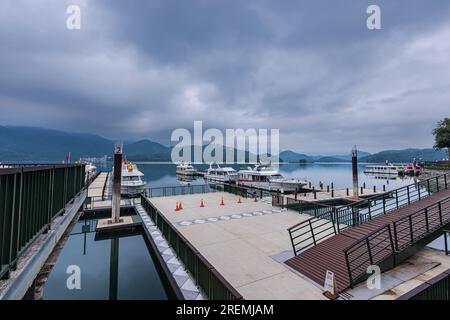 La vue matinale sur Sun Moon Lake Marina à Taiwan est à couper le souffle, avec des eaux calmes reflétant le lever du soleil vibrant, entouré de monta verdoyante Banque D'Images