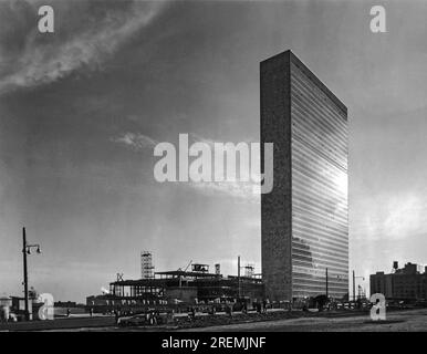 New York, New York : octobre 1950. Dans l ' ombre du bâtiment du Secrétariat nouvellement construit, les travailleurs travaillent dur pour construire le bâtiment de l ' Assemblée générale dans le nouveau siège permanent de l ' ONU sur l ' East River à Manhattan. Banque D'Images