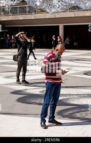 Stockholm, Suède - 23 mai 2023 : Homme à la longue barbe regardant son téléphone portable Banque D'Images