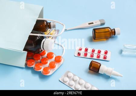 Sac à provisions avec différents médicaments sur fond bleu Banque D'Images