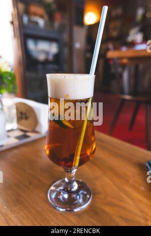 Cocktail rafraîchissant PIMm's Cup avec de la paille sur une table en bois Banque D'Images