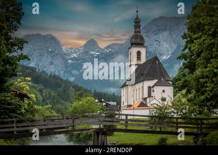 Paysage photographié, église à Berchtesgaden. Rivière et montagnes au coucher du soleil Banque D'Images