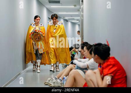 Chine. 29 juillet 2023. (230729) -- CHENGDU, 29 juillet 2023 (Xinhua) -- Ren Xin (à gauche) et son collègue se rendent dans la salle d'attente avec des costumes de « bian lian » avant une répétition de la cérémonie d'ouverture à Chengdu, dans la province du Sichuan, dans le sud-ouest de la Chine, le 23 juillet 2023. REN Xin, une étudiante de 19 ans, était fascinée par la danse depuis son enfance. Elle a été l'une des actrices et actrices qui ont interprété la traditionnelle 'bian lian', ou changement de visage lors de la cérémonie d'ouverture des 31e Jeux universitaires mondiaux d'été de la FISU à Chengdu le 28 juillet 2023.Ren Xin, qui est né dans une montagne éloignée Banque D'Images