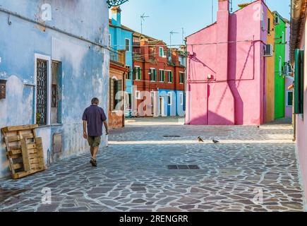 Vue arrière non identifiable d'un homme local sur les ruelles colorées étroites de Burano, Venise Banque D'Images