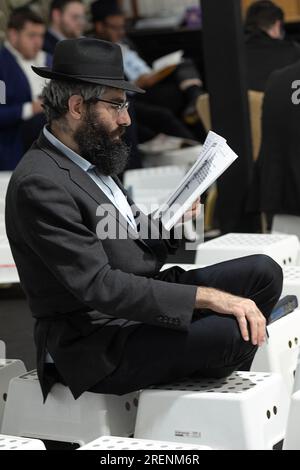 Aux offices du matin de Tish B'AV, un juif orthodoxe s'assoit sur des tabourets bas correspondant aux lois de deuil de la journée. Dans le comté de Rockland, NY Banque D'Images