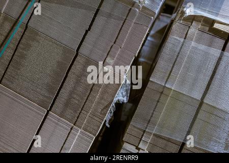 Boîtes pliantes en carton. Feuilles perforées de carton ondulé une pile sur palettes. Emballage de produits finis en production industrielle. Banque D'Images