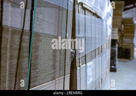 Boîtes pliantes en carton. Feuilles perforées de carton ondulé une pile sur palettes. Emballage de produits finis en production industrielle. Banque D'Images