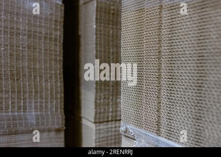 Boîtes pliantes en carton. Feuilles perforées de carton ondulé une pile sur palettes. Emballage de produits finis en production industrielle. Banque D'Images