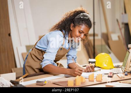 Menuisier Femme travaillant le bois dans l'atelier Designer Building Wood Home. Architecte femmes Smart Work. Happy Joiner Ingénieur en construction avec Design Floor Banque D'Images