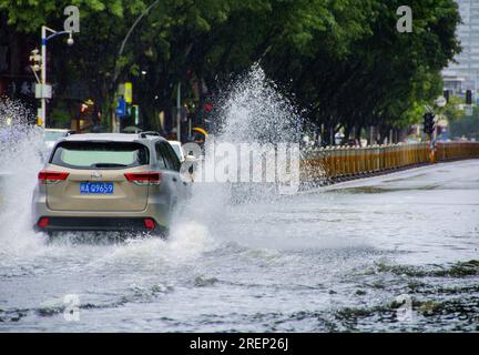 Chine. 29 juillet 2023. (230729) -- FUZHOU, 29 juillet 2023 (Xinhua) -- Une voiture traverse une rue inondée dans le district de Jin'an de Fuzhou, dans la province du Fujian, dans le sud-est de la Chine, le 29 juillet 2023. Les transports publics, y compris les bus et les métros à Fuzhou, ont été temporairement suspendus samedi matin après que la ville ait lancé une intervention d'urgence de niveau I pour les tempêtes de pluie déclenchées par le typhon Doksuri. Touchée par le typhon, Fuzhou a connu de fortes pluies continues depuis vendredi. Plusieurs stations d'observation météorologique de la ville ont enregistré les précipitations quotidiennes les plus élevées de l'histoire, lea Banque D'Images