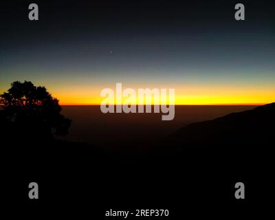 Vue exotique à 180 degrés de ligne hivernale orange avec des silhouettes de montagne à Mussoorie, Uttarakhand, Inde. Superbes paysages d'hiver. Banque D'Images