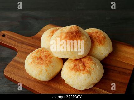 Pile de pains au fromage brésilien faits maison ou Pao de Queijo sur une planche à pain en bois Banque D'Images