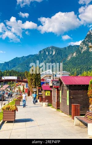 La rue principale Bulevardul Libertății avec des stands de vendeurs et vue sur les montagnes Bucegi, Busteni, Roumanie Banque D'Images