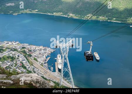 Téléphérique Romsdalgondolen descendant de la montagne Nesaksla avec 2 bateaux de croisière dans le port par la ville ci-dessous. Andalsnes, Møre og Romsdal, Norvège Banque D'Images