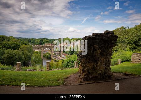 La gorge boisée de Nidd avec viaduc ferroviaire au-dessus de la rivière avec un fragment de mur du château de Knaresborough, Yorkshire du Nord. Banque D'Images