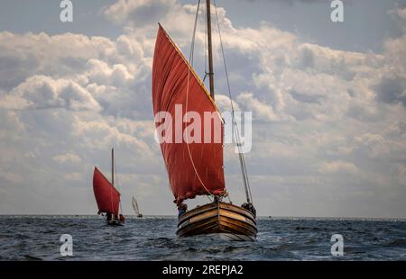 Les bateaux de pêche traditionnels Coble naviguent au large de Bridlington, dans l'East Yorkshire, pendant le Sailing Coble Festival. L'événement met en valeur les voiliers historiques et patrimoniaux. Date de la photo : Samedi 29 juillet 2023. Banque D'Images