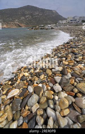 Plage de galets sur une rive d'île grecque. Galets humides colorés en perspective profonde. Banque D'Images