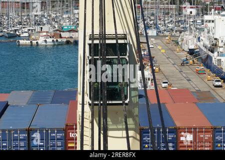 Vue directe sur la cabine de la grue de navire derrière le fil d'acier graissé du navire porte-conteneurs chargé amarré dans le port. Banque D'Images