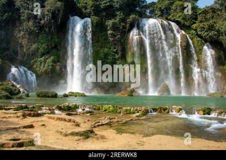 Ban Gioc-Detian Cascades à la frontière entre le Vietnam et la Chine par une belle journée, encadrées par une forêt luxuriante et une eau claire Banque D'Images