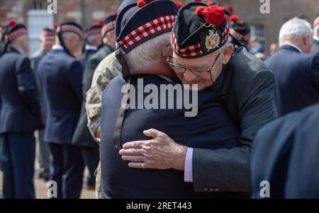 Berwick upon Tweed, Northumberland, Angleterre, Royaume-Uni. 29 juillet 2023 de vieux camarades embrassant. La King’s Own Scottish Borderers Association célèbre chaque année l’un de ses honneurs de bataille les plus célèbres le samedi le plus proche du 1 août, avec un défilé, la présentation de roses dans la caserne et une marche à travers la ville. Il commémore la participation de leurs précurseurs (25e régiment d'infanterie) comme l'un des régiments qui ont pris part à la bataille de Minden pendant la guerre de sept ans à cette date en 1759. Banque D'Images