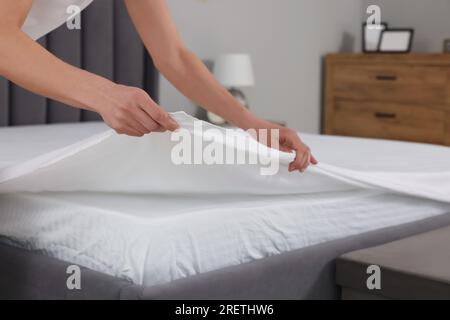 Femme changeant le linge de lit à la maison, à proximité Banque D'Images