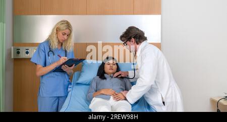 Médecin compatissant engagé dans une conversation avec le patient allongé sur un lit d'hôpital, représentant une scène de consultation médicale. Banque D'Images