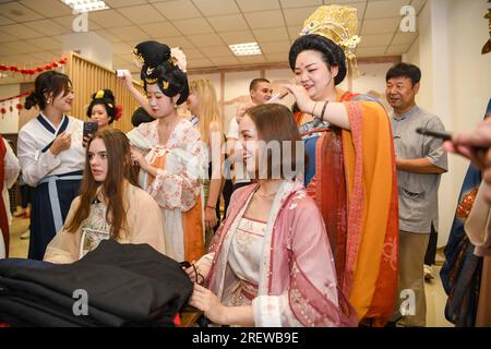 Urumqi, région autonome ouïgoure du Xinjiang. 23 juillet 2023. Une jeune fille locale vêtue de vêtements traditionnels chinois Hanfu peigne pour la danseuse russe Sofia Efremenko (devant, R) à la bibliothèque du Xinjiang à Urumqi, dans la région autonome ouïgoure du Xinjiang du nord-ouest de la Chine, le 23 juillet 2023. Crédit : Hu Huhu/Xinhua/Alamy Live News Banque D'Images