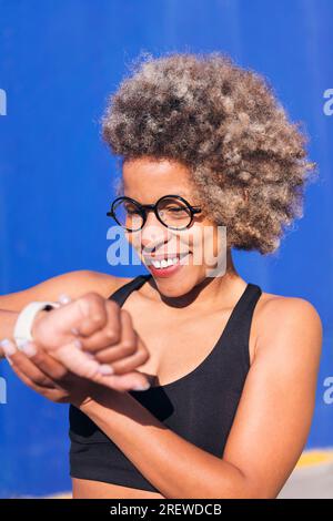 femme africaine sportive regardant la montre intelligente Banque D'Images