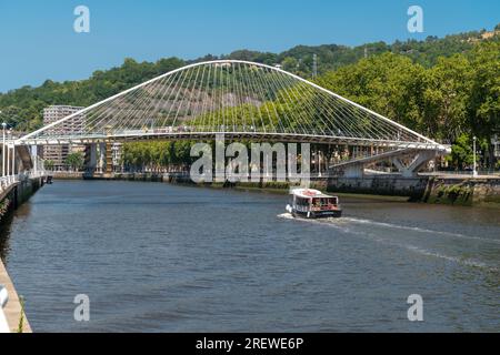 Pont Zubizuri, également appelé Pont Campo Volantin. Est une passerelle à arc lié sur la rivière Nervion à Bilbao, en Espagne. Les gens qui passent. Banque D'Images