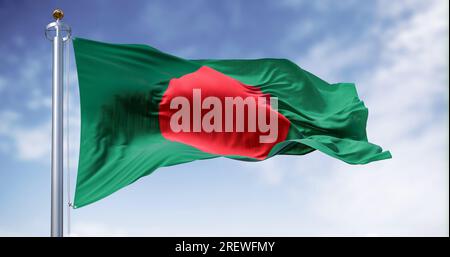 Drapeau national du Bangladesh agitant dans le vent par temps clair. Bannière vert foncé avec un disque rouge ou soleil sur le dessus. rendu d'illustration 3d. Fab. Volante Banque D'Images