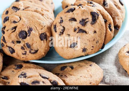 délicieux biscuits à la farine de blé et gouttes de chocolat à l'intérieur de la pâte sablée préparée, biscuits faits maison de forme ronde ou ovale irrégulière, gros plan Banque D'Images