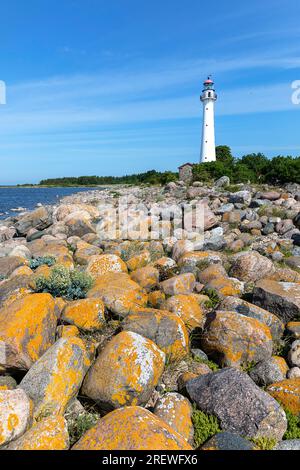 Spectaculaire plage rocheuse avec phare de Kihnu en arrière-plan sur l'île de kihnu dans la mer baltique, par une belle journée ensoleillée d'été, estonie Banque D'Images