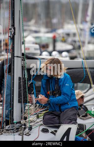 Jeune yachtsman effectuant des réparations ou de l'entretien du gréement sur un yacht de course pendant la régate de voile Cowes week sur l'île de wight au Royaume-Uni Banque D'Images