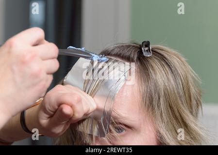 Position de fixation des cheveux sur la tête pendant le processus de teinture. utilisation d'une feuille d'aluminium. Banque D'Images