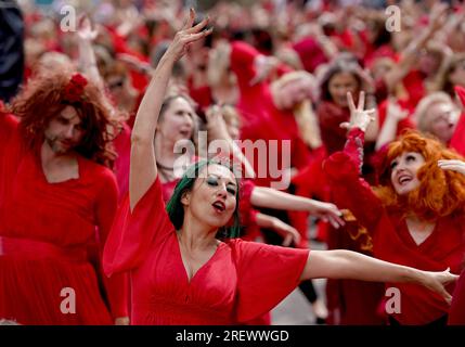 Les gens vêtus de rouge participent à un événement de danse de masse à Wuthering Heights de Kate Bush dans le cadre du Most Wuthering Heights Day, dans le port de Folkestone, Kent. Date de la photo : dimanche 30 juillet 2023. Banque D'Images