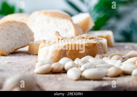 Ingrédients pour préparer un petit déjeuner rapide de pain et cacahuètes, cacahuètes grillées à la pâte d'arachides, délicieux beurre d'arachide et pain blanc sur la table, Banque D'Images