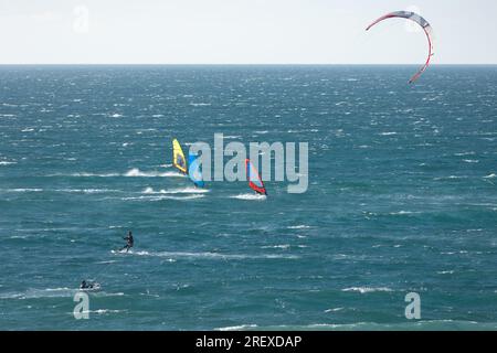 Les gens sont engagés dans différents types de surf dans l'océan bleu. Mid shot Banque D'Images